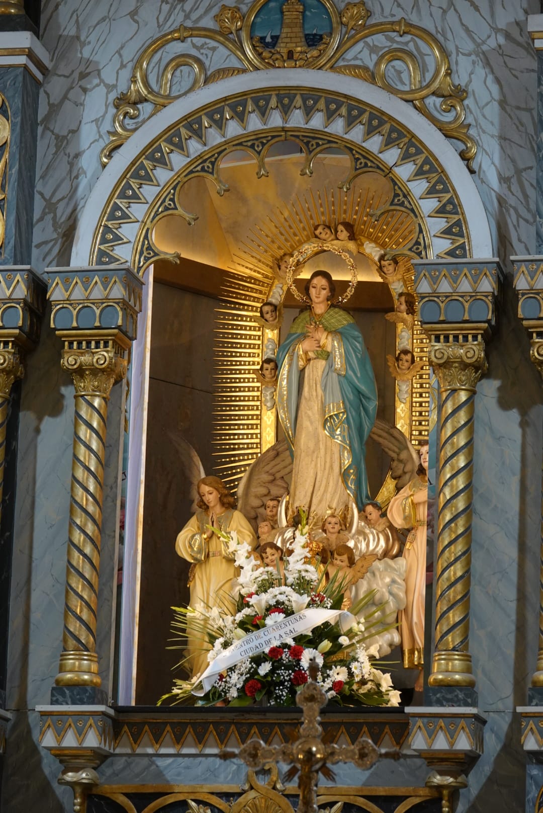 Kuvassa alttari, jossa keskellä Neitsyt Maria ympärillään enkeleitä. Marialla on sininen viitta kultaisin k...